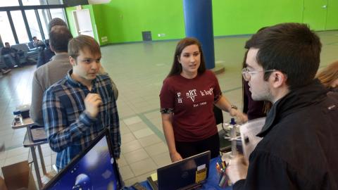 Alex Davie and Lexi Serwon discuss research with a visitor to biophysics table